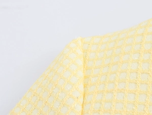 Macro detail of the yellow tweed fabric showing the premium woven mesh texture and luster