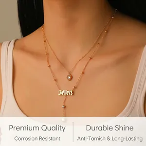 Macro detail of gold-plated MOM layered necklace with heart charms on model