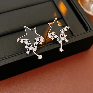 Macro shot of silver star earrings with zircon droplets on a black jewelry stand