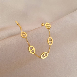 Detail of gold titanium steel bracelet with anchor chain links on silk background