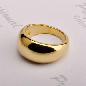 Macro shot of a wide gold dome ring with a polished metallic finish and mirror reflection