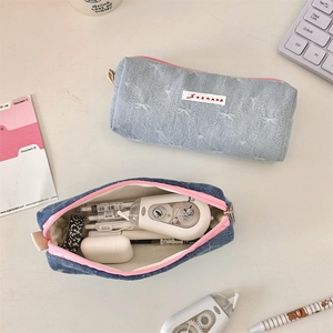 Detail view of denim stationery pouch showing spacious interior for pens and accessories
