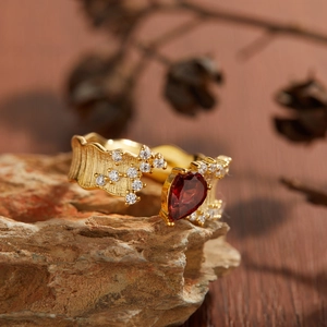 Detailed view of an 18K gold S925 ring with red garnet on natural stone
