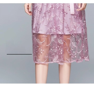 Detailansicht des lila Netzkleids Saum mit exquisiter Stickerei in Federform aus Spitze