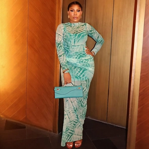 Detail of green tie-dye mesh dress with long sleeves and matching leather clutch bag