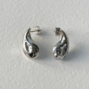 Close-up of teardrop stainless steel stud earrings with high-polish mirror finish