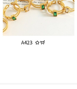 Detail view of gold twisted rings featuring square green and white zircon gemstones