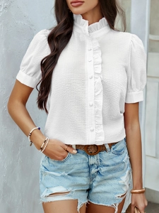 Detalle de la blusa blanca texturizada con mangas de volantes y botones delanteros