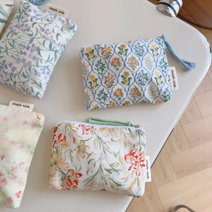 Floral cotton pouch set with zipper and simple wish label on light surface