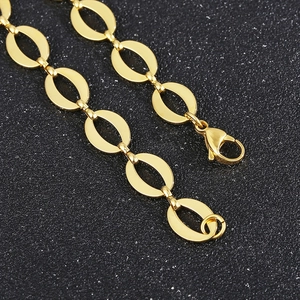 Detail of gold oval link chain necklace with lobster clasp in a minimalist fashion design