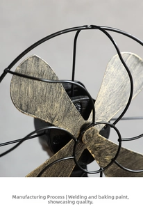 Close-up of vintage industrial decorative fan with golden distressed blades and iron mesh
