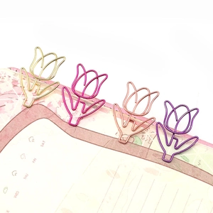 Close-up of four colorful tulip-shaped metal paperclips used as creative bookmarks