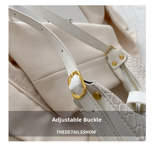 Macro detail of golden buckle and woven texture on a white leather crescent bag