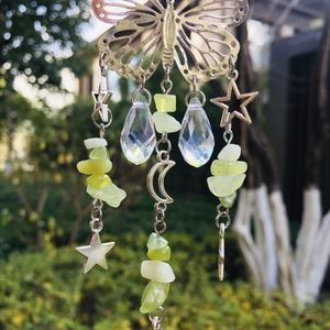 Detail of suncatcher with butterfly and moon pendants, featuring light green crystals