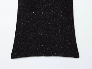 Detaillierte Nahaufnahme der schwarzen Pailletten-Stofftextur an einem Mini-Kleid