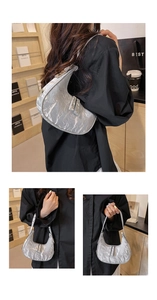 Detail of silver crescent hobo bag featuring metallic wrinkled texture and dual zippers