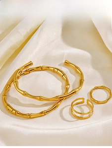 Detailed view of 18K gold plated bamboo texture jewelry set on soft silk fabric