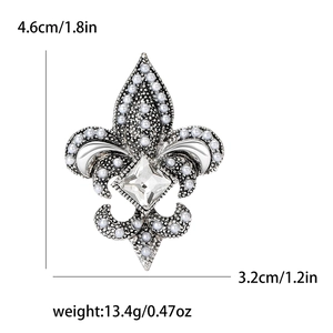 Broche iris argentée avec perles blanches et strass carré sur fond blanc pur