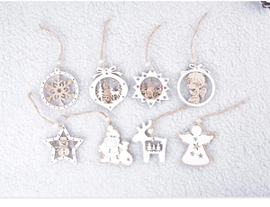 Flat lay of 8-piece wooden Christmas ornaments with snowflake and reindeer motifs on white fur