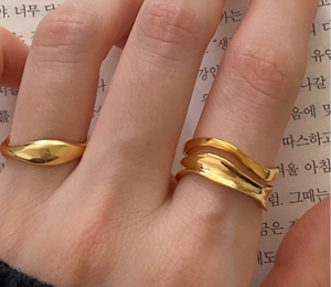 Detailed view of 925 sterling silver minimalist wave ring and smooth gold band ring
