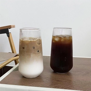 Detailed view of ribbed glass cups with iced latte and americano on wooden table