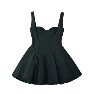 Detalle de mini vestido negro palabra de honor con cintura ceñida y falda de tablas