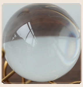 Macro shot of a clear crystal ball on a decorative gold metal artistic base stand