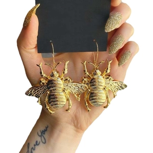 Vintage oversized gold bee earrings featuring detailed insect charms on long hooks