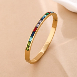 Detail view of gold stainless steel bangle with multi-color cubic zirconia inlay