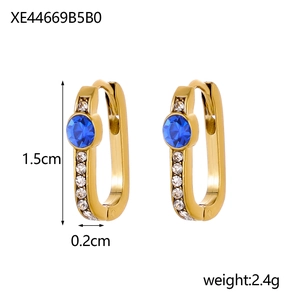 Detailed view of gold hoop earrings with central blue stone and zircon side accents