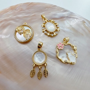 Detail of 18K gold plated charms with natural shell cat and goldfish designs