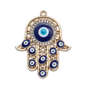 Macro shot of Hamsa hand evil eye charm with blue details and white rhinestones