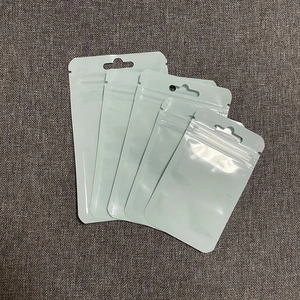 Detailed view of white plastic self-sealing bags with hanging holes on grey fabric