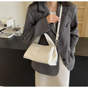 Litchi pattern faux leather handbag detail with adjustable strap in cafe setting