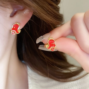 Macro detail of red enamel gourd earrings with gold finish and rhinestone accents