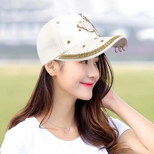 Détails d'une casquette blanche avec fleurs en paillettes et bordure dorée