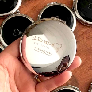 Portable round folding metal cosmetic mirror with custom logo on wood background