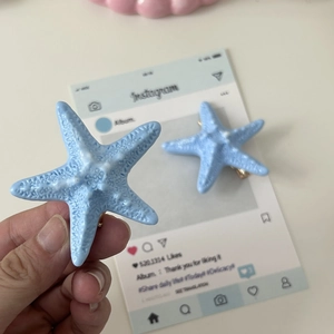 Detailed macro view of a light blue starfish hair clip showing realistic textured resin finish