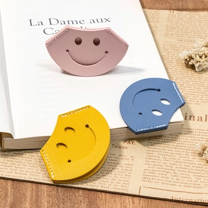 Three colorful leather smiley bookmarks in pink, blue, and yellow with hand-stitched edges