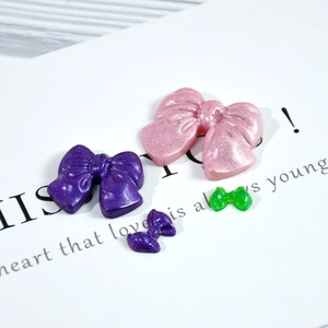 Détail de nœuds en résine violette et rose pailletée pour accessoires de cheveux DIY