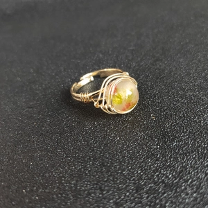 Detailed macro view of gold wire-wrapped ring with natural crystal stone inclusions