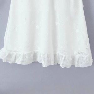 White sleeveless dress with hollow lace knit texture and elegant ruffled hem detailing