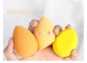 Close-up of soft yellow makeup sponge set with cute cat prints and water-drop shapes