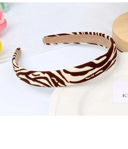 Close-up of brown zebra print sponge headband on a decorative plate with flowers