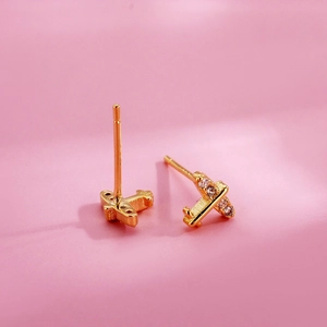 Cute golden airplane stud earrings for women with sparkling white crystals on pink background