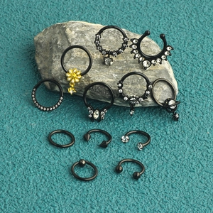 Close-up of black seamless stainless steel piercing set with zircon on stone