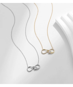 Detail view of gold and silver S925 infinity heart necklaces with shimmering cubic zirconia