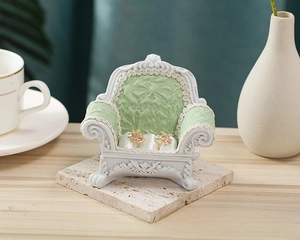 Detail of European retro sofa jewelry stand with mint green padding and heart earrings
