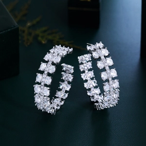 Elegant silver C-shaped earrings with double-row crystals on black luxury background