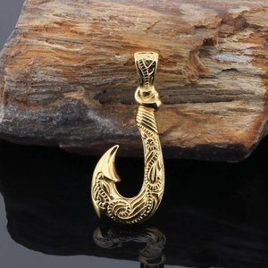 Detailed macro view of golden stainless steel fish hook pendant with engraved texture